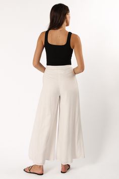 DETAILS   Are you ready to turn heads and show off your style? We've got the perfect pant for you! These wide leg pants are ideal for making a chic statement and will take your wardrobe up a notch. The high waist, front pleating detail, belt loops, and functional pockets add to their stylish appeal.  wide leg style pant  high waisted  elasticised waistband at back  front invisible zip with button close  belt loops  functional pockets  lined  material - 70% rayon / 30% linen    SIZING     model i Chic Wide-leg Culottes For Day Out, Chic Culottes With Loosely Fitted Hips, Chic Wide-leg Pants, Chic Wide Leg Trousers, Chic Wide Leg Culottes With Loosely Fitted Hips, Chic High-waisted Wide Leg Pants With Side Slits, Chic Wide Leg Culottes, Chic High-waisted Culottes, Chic Solid Color Culottes With Loosely Fitted Hips