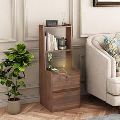 a living room with a couch, chair and book shelf next to a potted plant