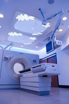 an mri room with medical equipment in the corner and lights on above it's doors