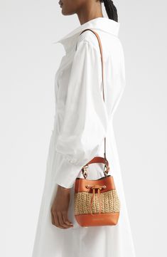 Inspired by the rocky coastline of Ibiza, this softly structured bag features a top handle and Strathberry's signature bar hardware at the drawstring closure. Drawstring closure Top carry handle; removable, adjustable crossbody strap Raffia/leather Made in Spain Designer Handbags Designer Travel Bag With Braided Handles, Trendy Natural Bucket Bag With Detachable Strap, Modern Bucket Satchel With Braided Handles, Luxury Summer Bucket Bag With Gold-tone Hardware, Luxury Bucket Bag With Gold-tone Hardware For Summer, Luxury Spring Bucket Bag For Daily Use, Designer Summer Bucket Bag With Double Handle, Designer Summer Bags With Leather Handles, Spring Luxury Bucket Bag With Detachable Strap