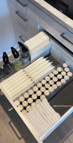 an open drawer in a kitchen filled with candles and other items to make soaps