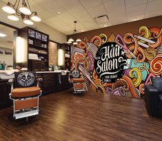 the interior of a barbershop with an artistic mural on the wall