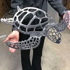 a person holding a turtle shaped object in their hands