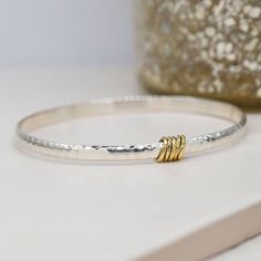 This handcrafted  sterling silver bangle had been expertly made and polished to a high shine. Looks fantastic alone and also stacked with others to create your own tailored look. The design features a beaten surface and little brass rings.l This gorgeous bracelet is a pleasure to wear and the perfect gift for someone who deserves a special thank you. We don't mind if you treat your self either 😊 Size Medium **Fully Hallmarked ** Your beautiful handmade silver bangle will arrive in one of our lu Stackable Sterling Silver White Gold Bangle, Stackable Sterling Silver Bangle In White Gold, Stackable White Gold Sterling Silver Bangle, Sterling Silver Oyster Bracelet For Anniversary, Sterling Silver Stackable Bangle For Anniversary, Stackable Sterling Silver Bracelet For Anniversary, Anniversary Sterling Silver Bangle With Silver Clasp, Sterling Silver Clasp Bangle As Gift, Gift Polished Sterling Silver Bangle Bracelet