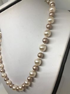 This two tone pearl necklace is hand knotted with white silk thread using 8mm Swarovski powder almond and 10mm Swarovski cream rose pearls at a classic length of 20 inches. These two colors compliment each other with soft pink tones. NOTE: See pic #2 outside photo of necklace for a better color description. I have finished this statement necklace with a sterling silver filigree fishhook pearl clasp. FREE sterling silver stud earrings in matching 8mm cream rose pearls included!! This necklace wil Elegant Single Strand Cream Pearl Necklace, Elegant Cream Single Strand Pearl Necklace, Elegant Cream Single Strand Necklace, Cream Pearl Necklace With Pearl Charm, Cream Pearl Chain Jewelry, Cream Pearl Drop Necklaces With Round Beads, Cream Pearl Chain Jewelry With Round Beads, Cream Pearl Drop Necklace With Round Beads, Cream Jewelry With Pearl Charm And Round Beads