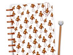 a brown teddy bear pattern on a white background next to a pen and notebook cover