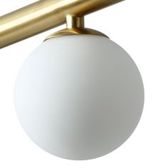 a white ball hanging from a gold colored metal arm on a light fixture with a white background