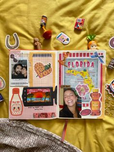 an open scrapbook with pictures and magnets on the cover next to a blanket