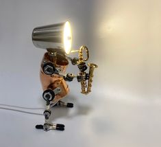 a desk lamp that is shaped like a human hand with a saxophone on it's leg