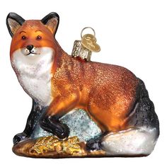 a glass ornament with a fox on it's back and a key in its mouth