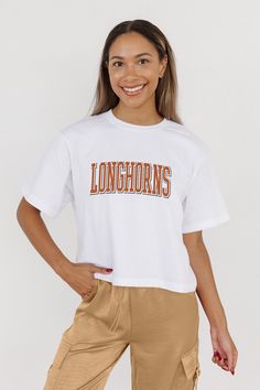 Every day is game day with our Texas Longhorns midi-length, boxy fit cropped tee with drop shoulder sleeves. Perfect for game day excitement or casual outings, this versatile tee is a must-have addition to your wardrobe. Sporty White Cropped T-shirt With Logo Print, White Athleisure Tops For Game Day, Casual Cropped T-shirt With Letter Print For College, White Cropped T-shirt For Sports, Sporty White Cropped T-shirt With Text Print, White Sporty Cropped T-shirt With Text, White Athleisure Tops For College, Casual White Cropped T-shirt For Sports, White Cotton Cropped T-shirt For Sports