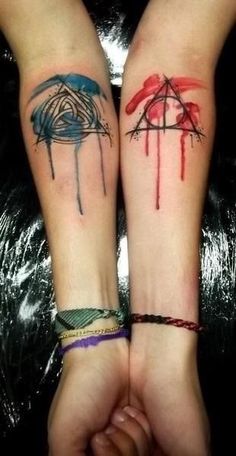 two people holding hands with tattoos on their arms and armbands that have been drawn onto each other