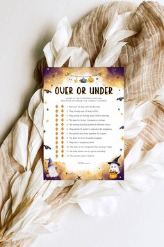 an over or under halloween party game with white feathers on it and a trick list