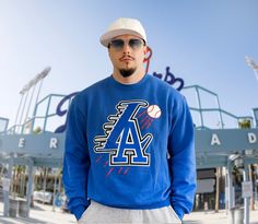 "Design Name \"LA Represent\" Los Angeles born. Colorway:Blue 294 print. T-shirt Brand Gildan 6 oz 100% preshrunk combed ring spun cotton Classic fit Seamless non-topstitched 7/8\"collar Taped neck and shoulders 7/8\" double needle sleeve and bottom hems Quarter-turned to eliminate center crease Hoodie Brand: Independent Trading Co. - Heavyweight Hooded Sweatshirt - IND4000     10 oz./yd² (US) 16.7 oz./L yd (CA), 80/20 cotton/polyester blend 3-end fleece with 100% cotton face, 32 singles     Solid colors direct from the mill are 70/30 cotton/polyester (Sold in US)     Charcoal Heather is 55/45 cotton/polyester     Charcoal Heather, Gunmetal Heather & Grey Heather direct from the mill are 52/48 cotton/polyester (Sold in US)     Safety Yellow & Safety Orange are 52/48 cotton/polyester     Ge Sports Fan Long Sleeve Hoodie For Streetwear, Throwback Fan Merchandise Hoodie Sweatshirt, Throwback Crew Neck Hoodie For Fan Merchandise, Sports Fan Long Sleeve Tops For Streetwear, Blue Fleece Fan Merchandise Sweatshirt, Long Sleeve Tops For Sports Fans Streetwear, Blue Pre-shrunk Sweatshirt For Streetwear, Collegiate Streetwear Sweatshirt For Baseball Season, Long Sleeve Sweatshirt For Baseball Season Streetwear