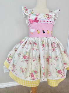 "This absolutely darling limited edition toddler dress is the sweetest confection ever! Perfect for little ones who love baby animals and reminiscent of favorite childhood stories, the bodice features detailed little ducklings waddling behind their mother. They are appliquéd atop a pink on pink dotted polished cotton and trimmed with ruffled white eyelet laced with pink ribbon. The ruffled flutter sleeves are trimmed in dainty white cotton lace. The skirt is fluffy extra full, also trimmed with Easter Dresses With Ruffles And Short Sleeves, Whimsical Spring Tea Party Dresses, Spring Whimsical Flutter Sleeve Dresses, Cute Ruffled Dresses For Easter, Cute Easter Dresses With Ruffles, Cute Ruffled Easter Dresses, Cute Dresses For Playtime During Easter, Playful Ruffled Dresses For Easter, Childhood Stories