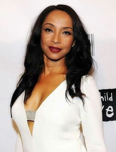 a woman in a white dress posing for a photo on the red carpet at an event