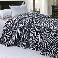 a zebra print comforter on a bed in a bedroom