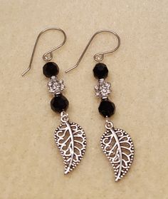 pair of earrings with black beads and silver leaves