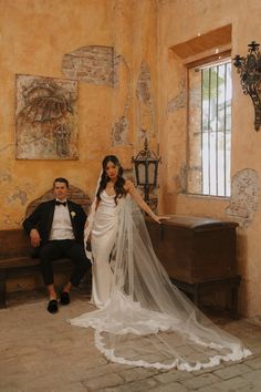 a bride and groom posing for a photo in an old - fashioned room with large windows