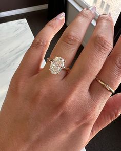 a woman's hand with a ring on it and a diamond in the middle