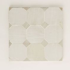 a white and beige tile pattern on the wall