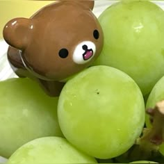 a teddy bear sitting on top of grapes