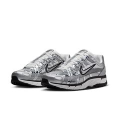 The Nike P-6000 'Metallic Silver' draws inspiration from the 2006 Air Pegasus, infusing it with futuristic flair. Its breathable metallic fabric upper features both vertical and horizontal overlays in chrome synthetic leather, creating a glistening effect. The silver side-panel Nike swoosh is outlined in black embroidery, complementing the black foxing and Nike branding on the tongue tag and heel tab. White laces match the tongue, sock liner, and insole, adorned with P-6000 branding. The comfort Nike P6000, Running Aesthetic, P 6000, Vans Top, Metallic Fabric, Nike Acg, Swag Shoes, Newest Jordans, To The Future