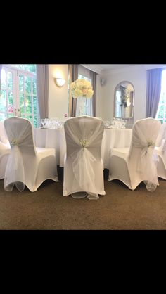 the chairs are covered with white cloths and sashes for an elegant wedding reception