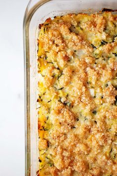 a casserole dish with cheese and spinach in it on a white surface