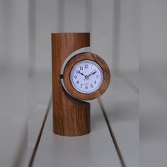 a small wooden clock sitting on top of a table