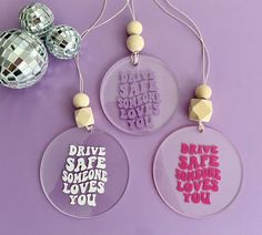 three ornament ornaments with disco balls on the side and one has words that say drive safe someone loves you