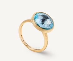 Boasting bright colors and clean lines, this ring is embellished by a carefully selected semi-precious gemstone, encircled in an 18K yellow gold bezel setting, hand-engraved using an ancient Florentine technique. It is perfect on its own or matched with the other colors in the collection. Marco Bicego, London Blue Topaz Ring, Branded Gifts, The Ultimate Gift, Blue Topaz Ring, London Blue Topaz, London Blue, High Jewelry, Handmade Design