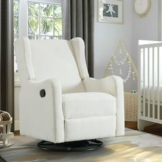 a white reclining chair in a nursery room next to a crib and window