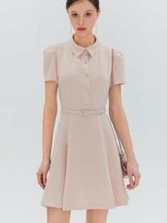 The Elina Mini Dress is a testament to classic elegance, designed with a sharp collar and a flared skirt. The belted waist and distinctive button detailing create a look that is at once modern and timeless. - The dress’s structured collar and sleek short sleeves impart a professional yet feminine look.- A series of sparkling buttons descend down the front, providing a striking contrast against the dress’s dark fabric.- Its cinched waist, accented with a slim belt, highlights the figure and adds to the dress’s tailored appearance.- The flare of the mini skirt brings a playful touch to the silhouette, making it suitable for both day and evening wear. Elegant A-line Shirt Dress With Button Closure, Elegant A-line Mini Dress With Pleated Waist, Elegant A-line Dress With Buttons, Chic Short Sleeve Belted Dress For Office, A-line Belted Dress For Evening, Elegant A-line Midi Dress With Belt, Fitted Belted Mini Shirt Dress, Formal Mini Dress With Fitted Waist, Elegant Belted Shirt Dress For Party