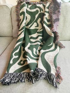 a green and white blanket sitting on top of a couch