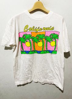 "Vintage 90s California Shirt Size: M Made In Dominican Rep Measurements are taken with the garment laying flat. Chest width: 19\" Body Length : 25\" Condition: Pre-owned 8.5/10 Material: 100% Cotton Comment Good Condition No refund. -Payment : accept paypal only -Shipping : to shipping worldwide by registered airmail (small package) Thai post registered. receiving the item within 7-30 business days non sat-sunday working after payment cleared  (some case in Australia/italy/spain/north and south america 2-4 weeks) I ship every day, monday through Friday! Many times your item will go out same day!! Get your stuff super fast when you buy from me! -Check item status out of my country: http://track.thailandpost.co.th 12 white" 90s California Aesthetic, 90s Shirts Graphic Tees, Graphic Tees Aesthetic, 90s California, Vintage Shirt Design, California Shirt, 90s Shirts, Vintage California, North And South