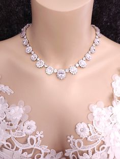 Tarnish resistant white gold rhodium plated metal framed oval shape collar necklace. Micropave cubic zirconia all around. Each oval size 10mm - 17mm tall. Three sizes: 15, 16, 17 inches.  Please inquire about different sizes. Matching bracelet available. https://www.etsy.com/listing/699412179/wedding-jewelry-bridal-bracelet?ref=shop_home_active_2&frs=1 Returns and exchange details   Customer Satisfaction Guarantee: Below policy will replace standard ETSY policy- please read carefully before purchasing. If you are not satisfied with an item for any reason, I will provide a full refund less the actual shipping and handling charge (usually around $4.00). The return or exchange request must be made within 3  days from the actual delivery date. All returns must be postmarked within 3 business d Oval Crystal Jewelry With Rhinestones, White Bridal Necklace With Rhinestones, White Halo Necklace With Cubic Zirconia, White Halo Cubic Zirconia Necklaces, White Cubic Zirconia Halo Necklaces, White Cubic Zirconia Halo Necklace, Dazzling White Rhinestone Necklace For Formal Occasions, Formal Dazzling White Rhinestone Necklace, White Crystal Jewelry With Halo Setting