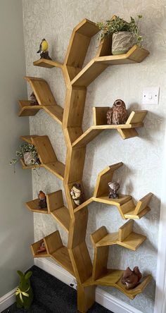 a wooden tree shelf filled with lots of shelves next to a wall mounted planter