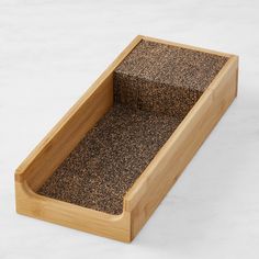 an empty wooden box with carpet inside on a white surface