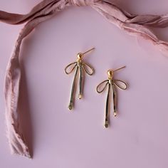 Look stunning this holiday season with these trendy bow earrings! Whether you're dressing up for a special occasion or just going out with friends, you'll be sure to make a statement with their large, bold design. Add some pizzazz to your festive outfit! …………………………………. Details: Earring is Gold Filled or Silver Plated, measuring 33.4mm x 19mm x 2.4mm Stud is 14k Gold Filled or Sterling Silver Nickel Free About Your Jewelry If you are not wearing your jewelry it is best to store it in a cool, dry Elegant Christmas Celebration Earrings, Chic Silver Earrings With Decorative Bow, Glamorous Silver Earrings With Bow, Glamorous Silver Bow Earrings, Elegant Holiday Party Jewelry, Trendy Gold Earrings For Party, Gold Holiday Drop Earrings, Elegant Evening Holiday Jewelry, Gold Earrings With Decorative Bow As Gift