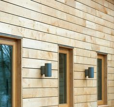 three windows on the side of a wooden building