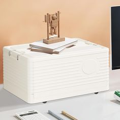 a white box sitting on top of a desk next to a computer