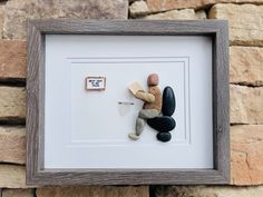 there is a framed picture with rocks and a teddy bear