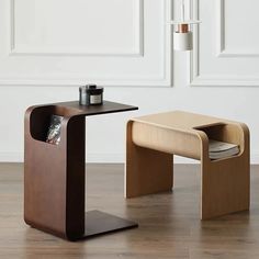 two wooden tables with magazine holders on them in front of a white wall and wood floor