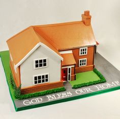 a cake shaped like a house with the words god bliss our home written on it