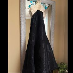 a black and white dress hanging in front of a mirror with a blue bow on it