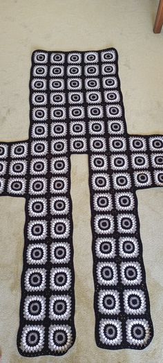 a black and white crocheted rug on the floor