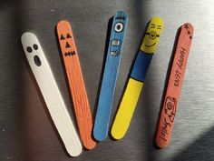 three wooden toothbrushes with faces and eyes on them are lined up next to each other