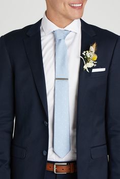 a man in a suit and tie with a boutonniere on his lapel