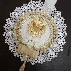 a doily with flowers and pearls on it sitting on top of a wooden table